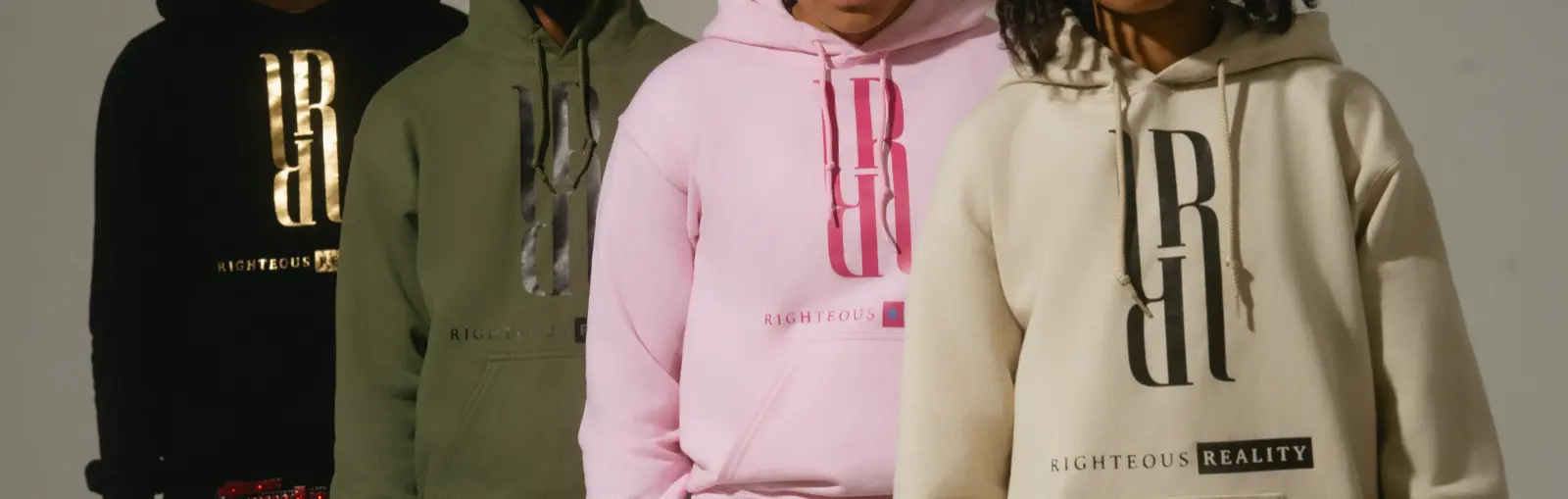 Four models in black, olive, pink and cream Righteous Reality hoodies standing in a row